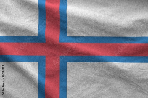 Faroe islands flag depicted on folded wavy fabric of old cloth close up photo