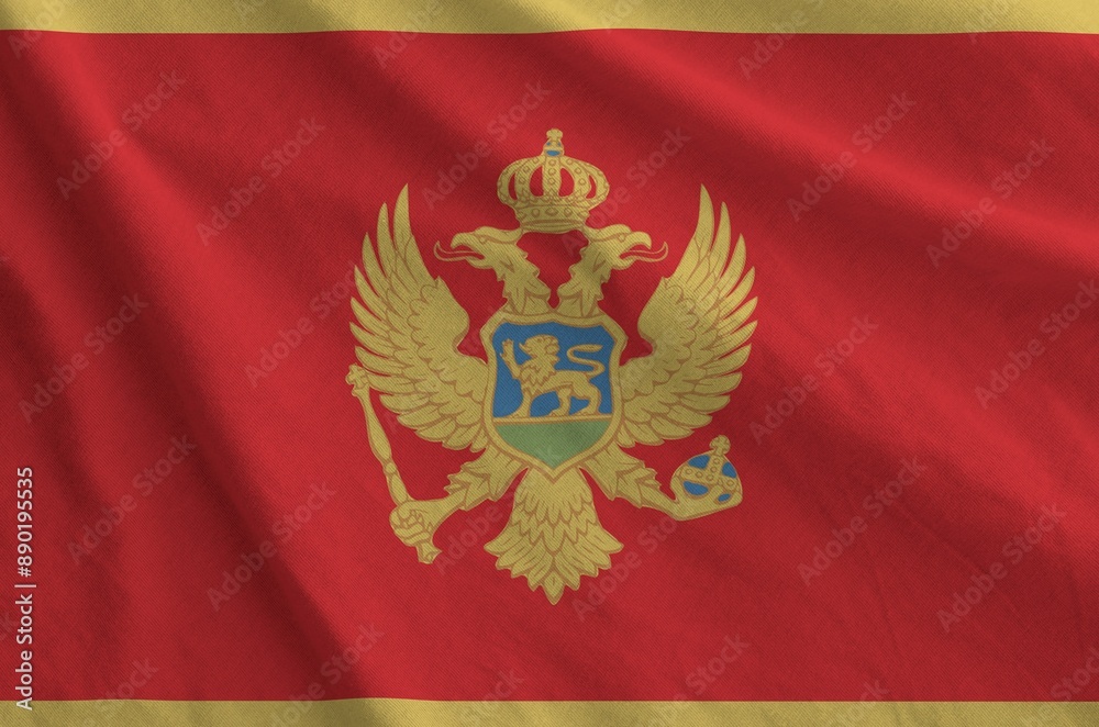 Montenegro flag depicted on folded wavy fabric of old cloth close up Montenegro flag depicted on folded wavy fabric of old cloth close up