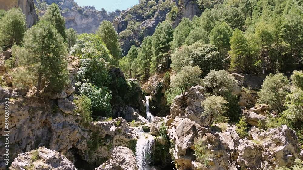 Aerial view of waterfalls among pine trees in nature at mountain range Aerial view of waterfalls among pine trees in nature at mountain range