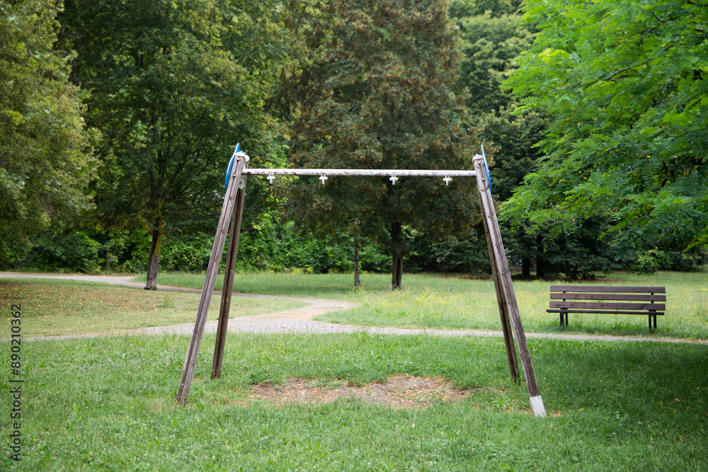 Fototapeta premium Deserted playground, neglected park, old swings, eerie atmosphere, abandoned site.