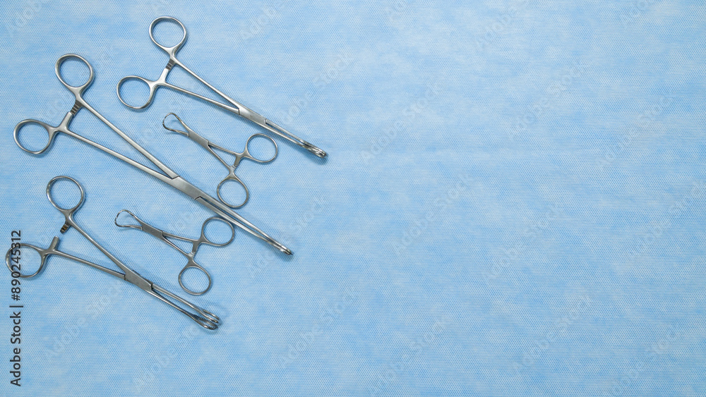 Fototapeta premium Stainless medical equipment used by surgeons in surgery placed on a blue background. Surgical instruments used in operating room.