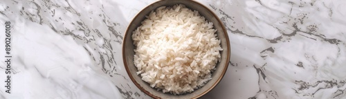 Bowl of white rice against a marble backdrop, offering a minimalist yet eye-catching visual ideal for culinary themes. Top-down view.