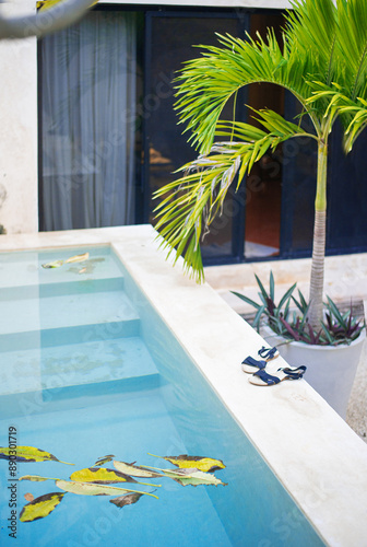 blue turquoise water of the swimming pool in a yard of the mexican villa in the dusk