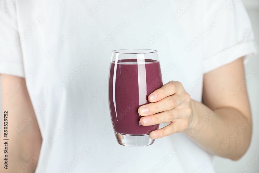 Woman with glass of tasty fresh acai juice, closeup