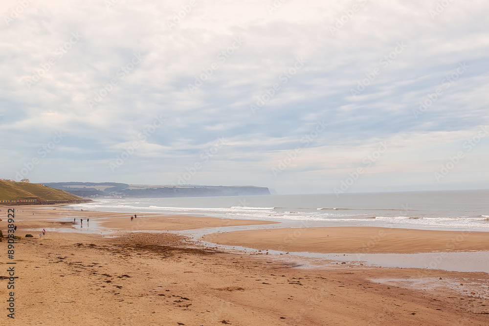 Overcast day at a serene beach with distant cliffs in Whitby, North Yorkshire Overcast day at a serene beach with distant cliffs in Whitby, North Yorkshire