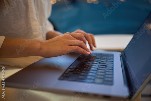 A person is typing on a laptop in a modern workspace, either for business or education purposes