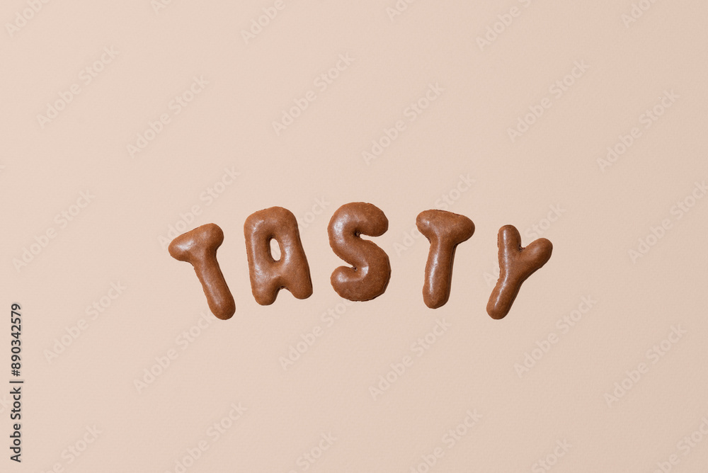 Sweet composition with the word Tasty on a beige background. Alphabet biscuits on a pastel background Sweet composition with the word Tasty on a beige background. Alphabet biscuits on a pastel background