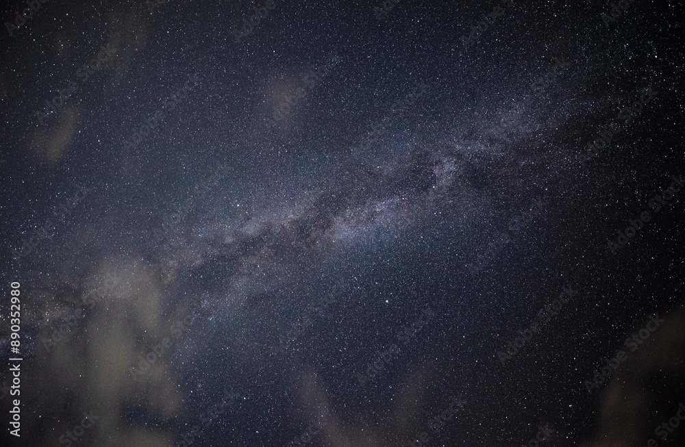 Obraz premium The Milky Way is a nebular cluster like a shining belt crossing the night sky.