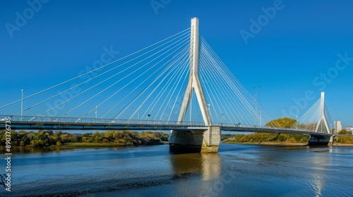 A cable-stayed bridge with modern architectural design, spanning a bustling river © Plaifah