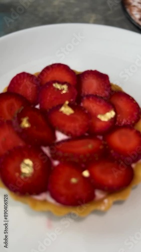 Delicious strawberry tart or tartlet with cut out strawberries and whipped cream decorated with edible gold flakes, good for multimedia recipe content photo