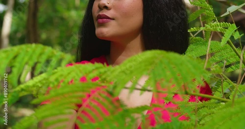 A young Hispanic girl in a red dress enjoying a tropical park in Trinidad. photo