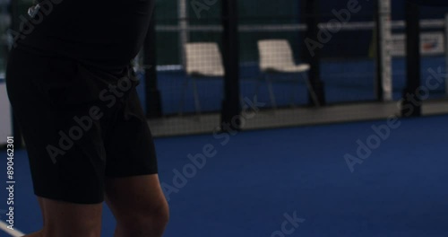 Super slow motion close up of paddle player is serving ball during competition game match or training workout on indoor court at 1000 fps.