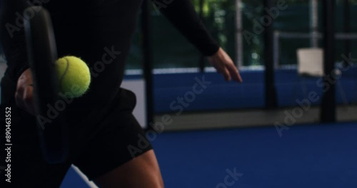 Super slow motion macro of paddle player is serving ball during competition game match or training workout on indoor court at 1000 fps.