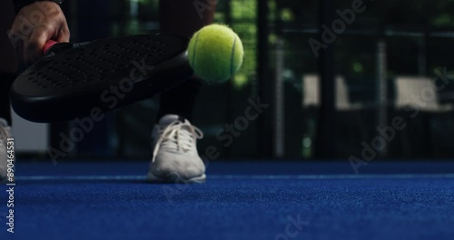 Super slow motion macro of paddle player is serving ball during competition game match or training workout on indoor court at 1000 fps.