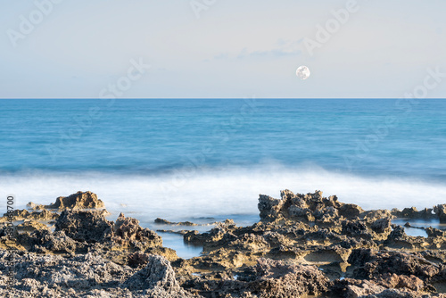 Ostuni, crenelated coast with moon on the horizon. long exposition. photo