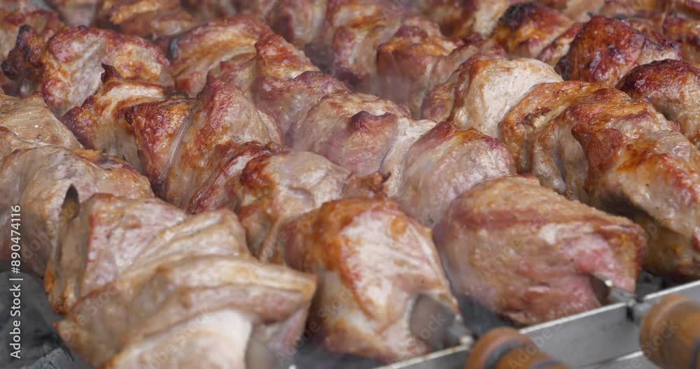Meat are cooked on hot coals in barbecue, rotates on skewers for roasting. Delicious hot kebabs. Shish kebabs broils in barbecue Meat are cooked on hot coals in barbecue, rotates on skewers for roasting. Delicious hot kebabs. Shish kebabs broils in barbecue