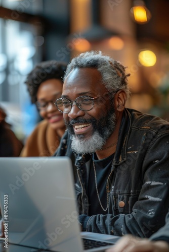 Senior Man Smiling While Working on Laptop © Jose