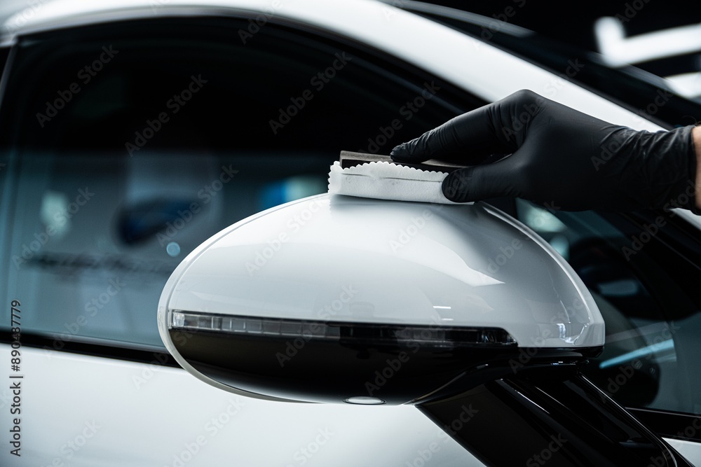 Applying ceramic coating on car side mirror using cloth. Focus on achieving high-gloss finish, protection, and precision in professional auto detailing.