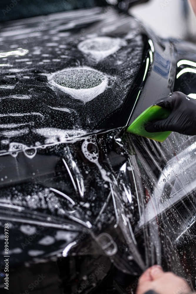 Detailing car wheel using brush for thorough cleaning. Focus on precision and high-quality finish in professional auto detailing, ensuring spotless and shiny wheels
