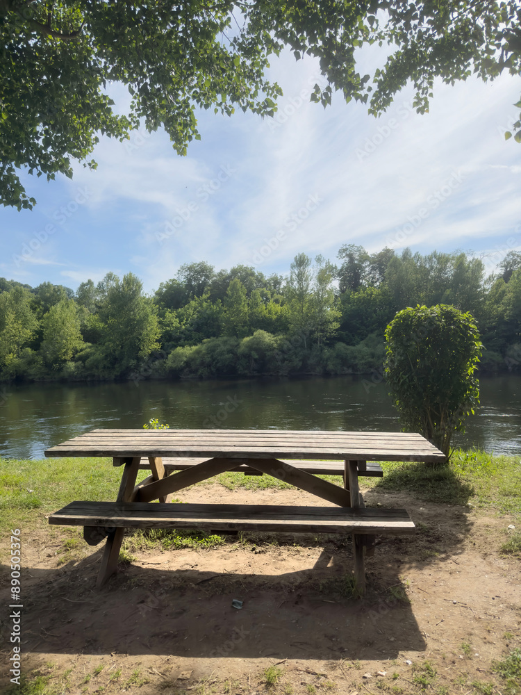 empty wooden picnic table in the park by river empty wooden picnic table in the park by river