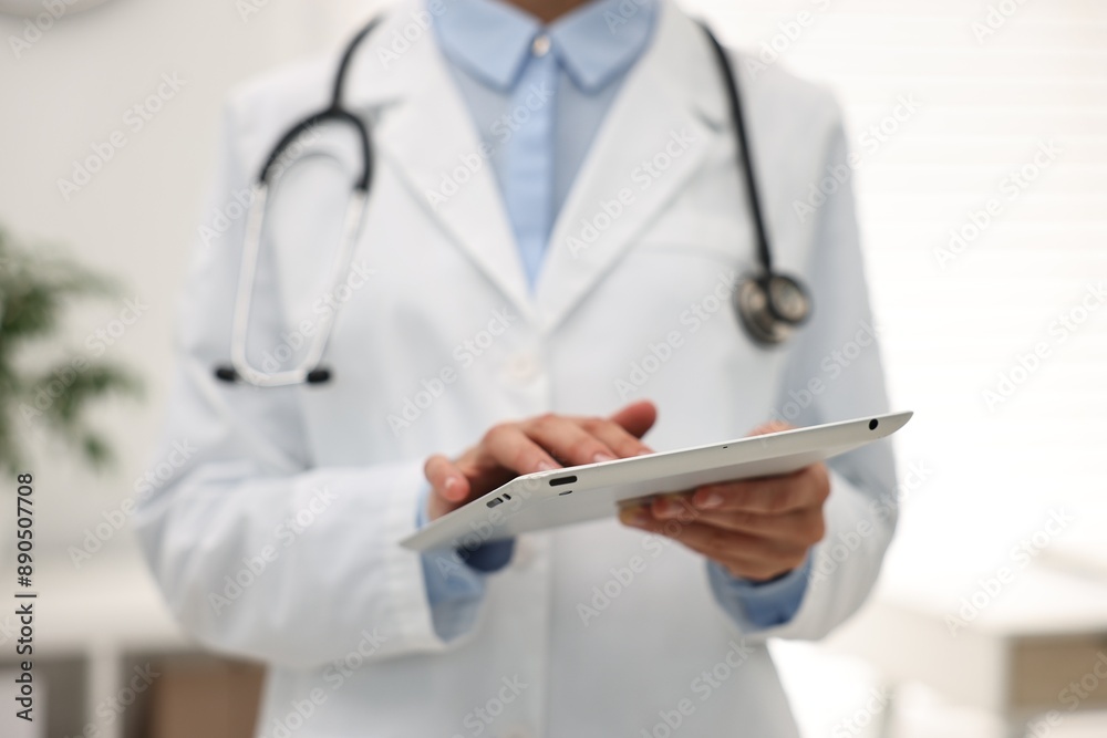 Doctor using tablet in hospital, closeup view
