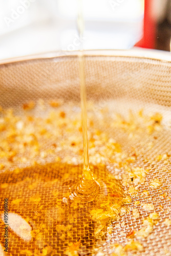 Viscouse Sweet Bee Honey Trickles Down Into the Sieve Mesh Extreme Close Up photo