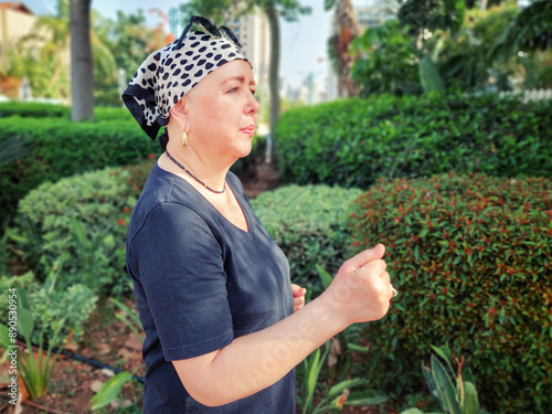 Jogging in a city park, a woman undergoing cancer treatment maintains her fitness routine to help manage chemotherapy's impact.