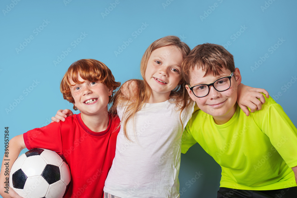 Laughing children with the soccer ball have fun, isolated on blue background.