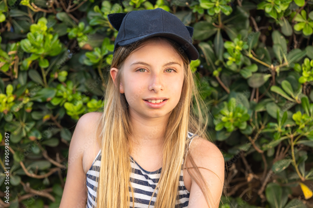 Cute Blonde Preteen Girl in Blue and White Striped Dress and Hat, Close-Up Portrait Cute Blonde Preteen Girl in Blue and White Striped Dress and Hat, Close-Up Portrait
