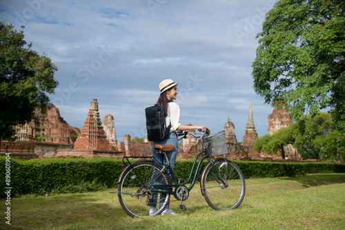 Young asian woman travel on holiday with bicycle, talking photo of world heritage site. Historical park of Ayutthaya, Thailand. photo