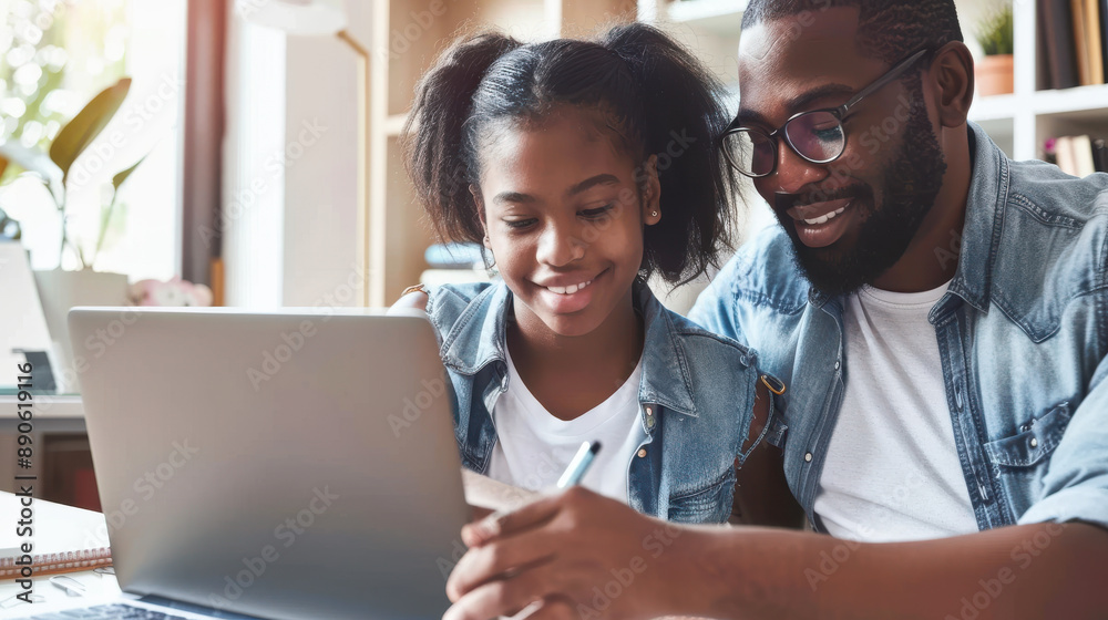 A father and his teenage daughter smiling as they study together at home, both engaged with a laptop for her schoolwork