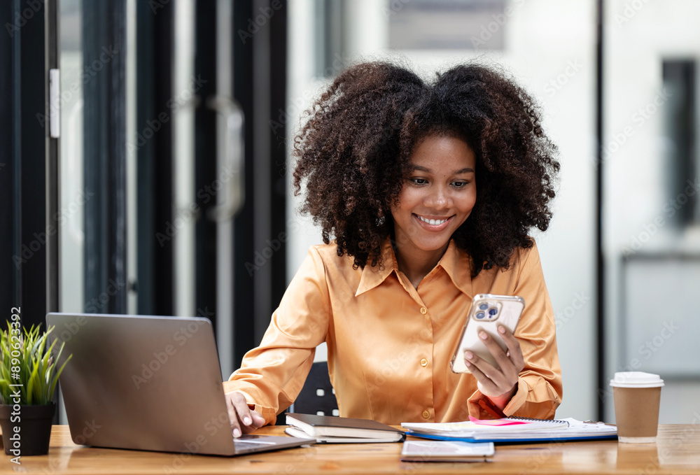 Cheerful young black woman using smartphone. Smiling woman using app on cellphone at office. Cheerful young black woman using smartphone. Smiling woman using app on cellphone at office.
