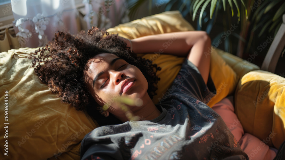 Obraz premium A woman, relaxed and content, basking in the natural light on a plush yellow pillow, evoking a lazy, blissful afternoon.