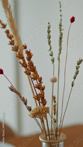 Delicate bouquet dry grass standing cafe closeup. Dried plant in vase vertical photo