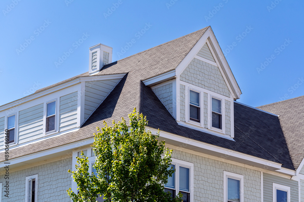 Dormer windows on the sloped shingle roof of a newly built house in Brighton, Massachusetts, USA Dormer windows on the sloped shingle roof of a newly built house in Brighton, Massachusetts, USA