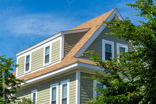 Картината върху платно Upper Section of a Newly Built House with Shed Dormer Against a Clear Blue Sky,