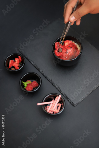 Obraz na plátně preparacion de creme brulee con fruta fresca y soplador, fuego en fondo gris y fondo negro