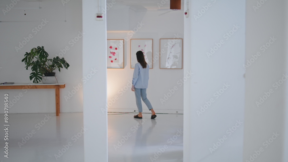 Gallery visitor looking paintings on weekend. Woman walking contemporary museum Gallery visitor looking paintings on weekend. Woman walking contemporary museum