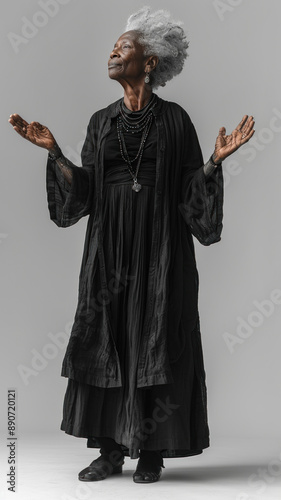 Elegant elderly woman in black dress with hands raised