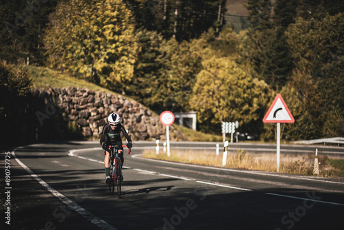 Wallpaper Mural A woman cyclist training on a lonely road on a sunny day wearing a black jersey and bib shorts and a white helmet. Torontodigital.ca