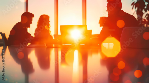 Silhouettes of professionals in a business meeting with a stunning sunset view, highlighting teamwork and collaboration in a modern office setting. photo