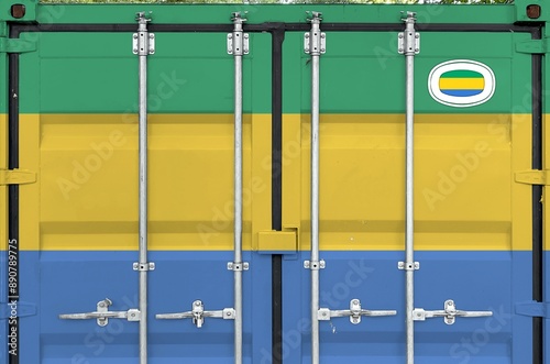 Gabon flag depicted on metal doors of shipping cargo container outdoors in docks area close up photo