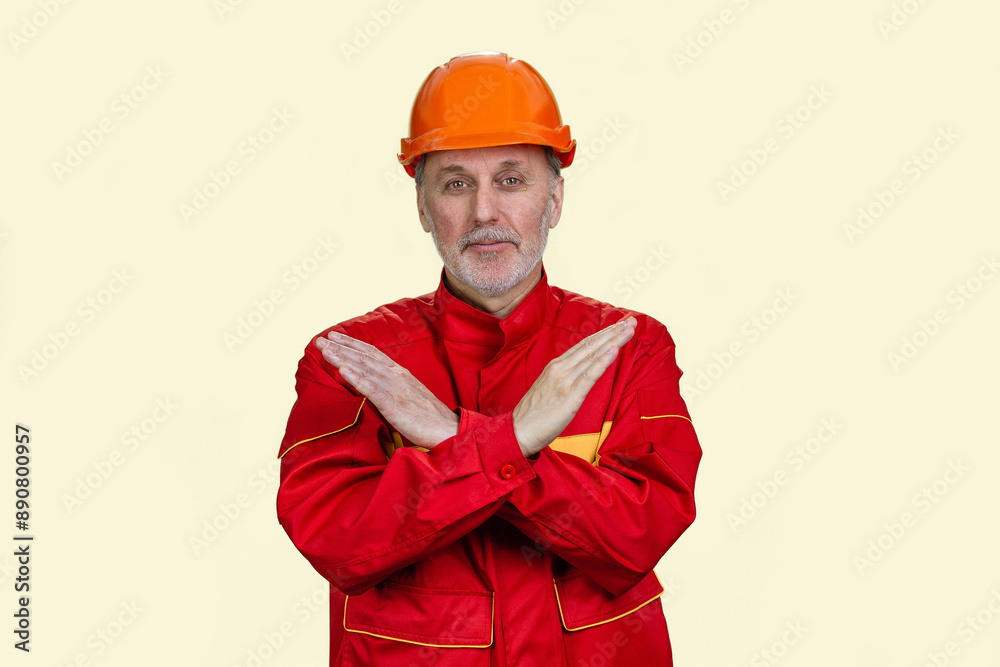 Handsome old caucasian worker shows the sign of prohibition. Isolated on white. Handsome old caucasian worker shows the sign of prohibition. Isolated on white.