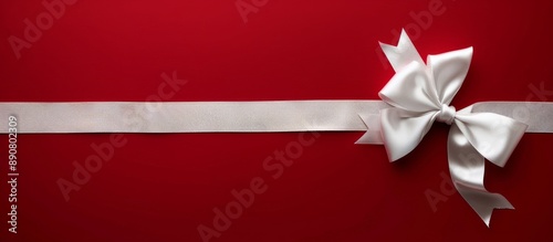 White Satin Bow on Red Background With Silver Ribbon