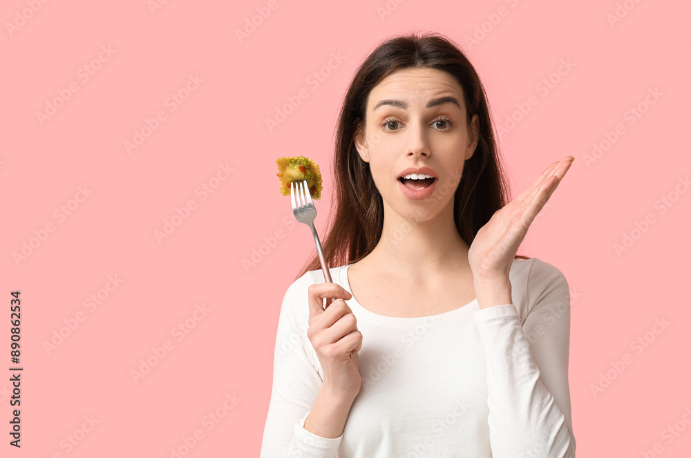 Surprised young woman holding fork with tasty ravioli on pink background Surprised young woman holding fork with tasty ravioli on pink background
