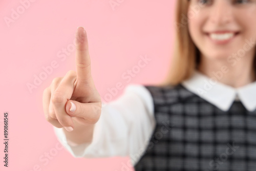 Young businesswoman using virtual screen on pink background, closeup
