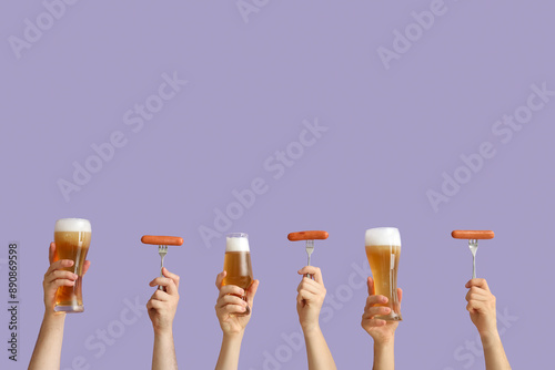 Many hands holding beer gla...
