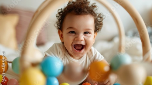A cheerful toddler with curly hair smiles broadly while playing with vibrant toys, capturing pure joy and happiness, surrounded by a playful, loving environment.