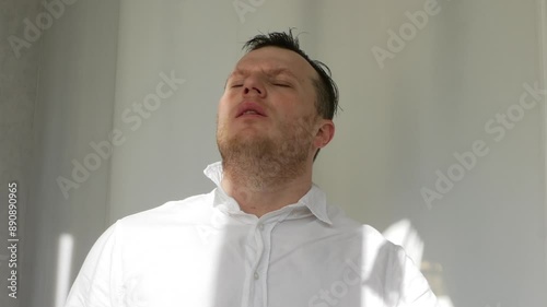 Morally tired elegant worker. Failure at work. A man is tired from office work. A man takes off his tie in a worker's office. People are hot in the summer.
