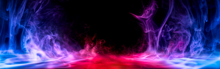 Dramatic smoke and fog effect in intense red, blue, and purple colors. Vivid and intense abstract background or wallpaper.